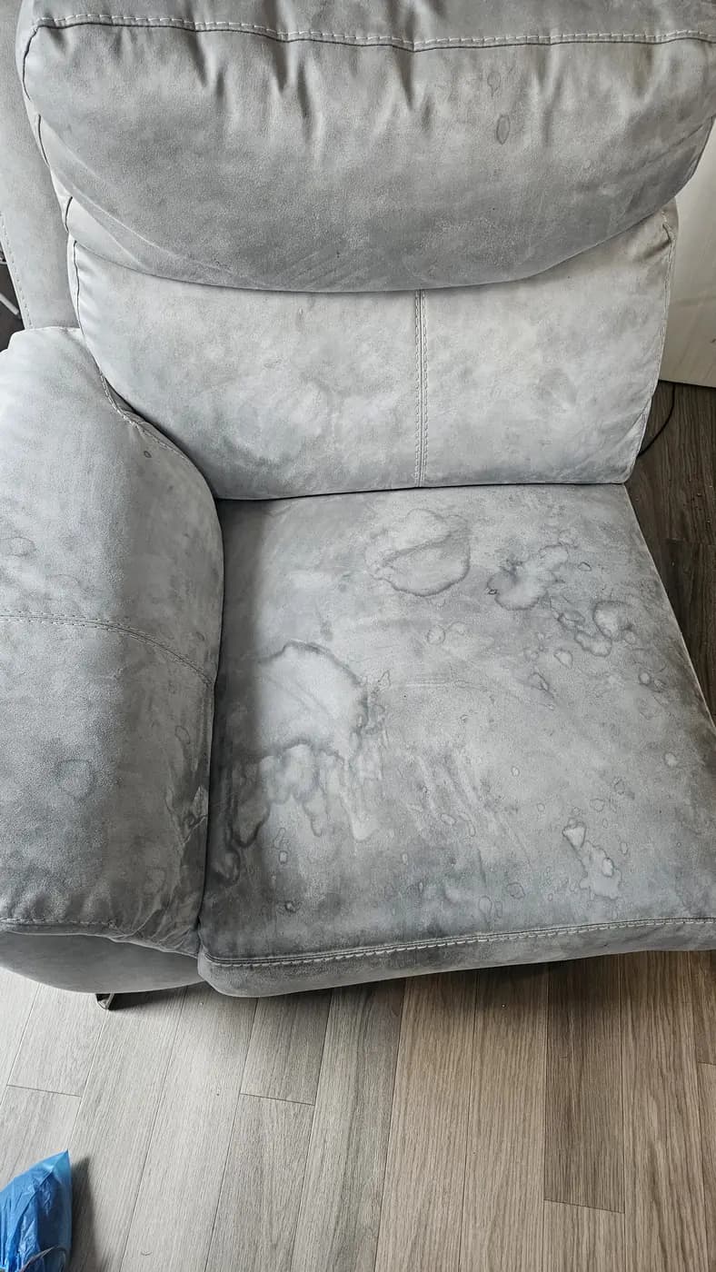 Grey fabric recliner with water marks before cleaning